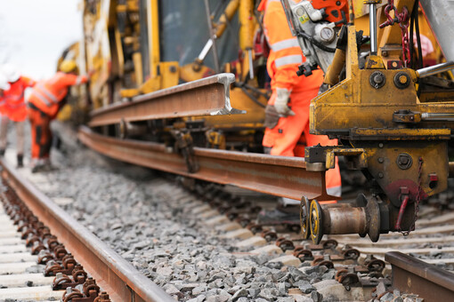 Bauarbeiter und Baumaschinen auf einer Schienenbaustelle